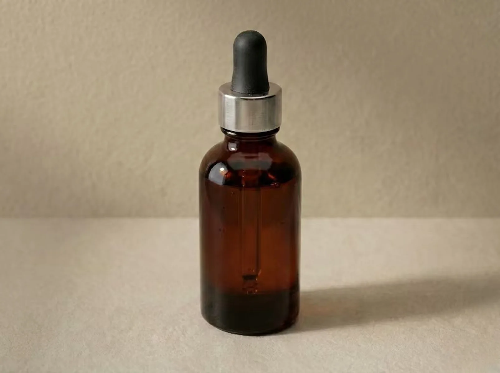 High-quality amber glass dropper bottle displayed under soft studio lighting.