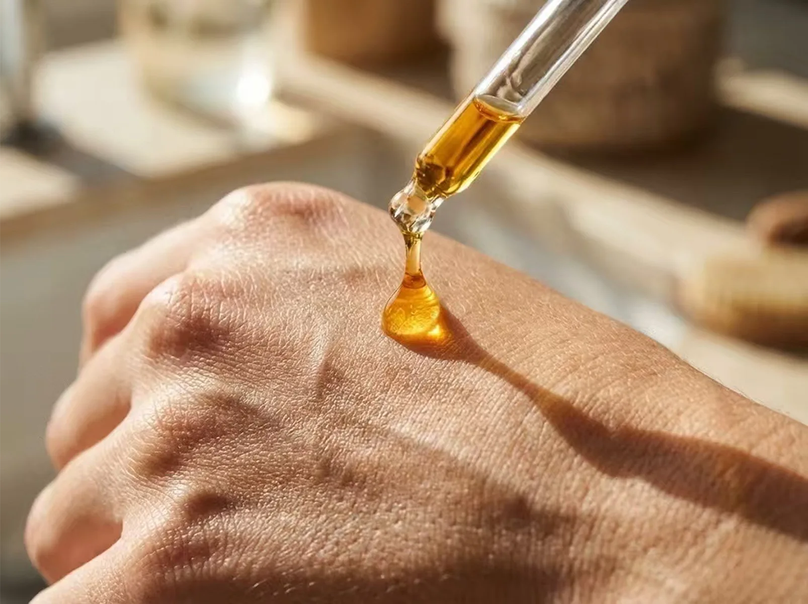 Lifestyle photography: A user precisely applying golden Vitamin C serum onto the back of their hand using a dropper.
