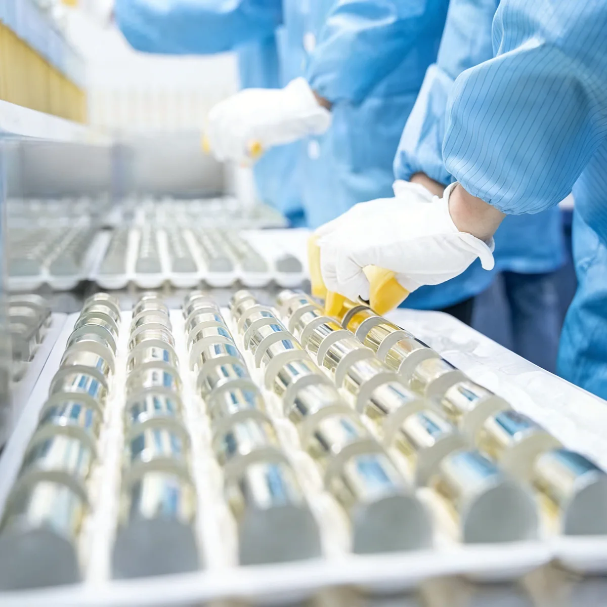 Detailed manual quality control inspection and assembly of luxury cosmetic packaging components by skilled workers.