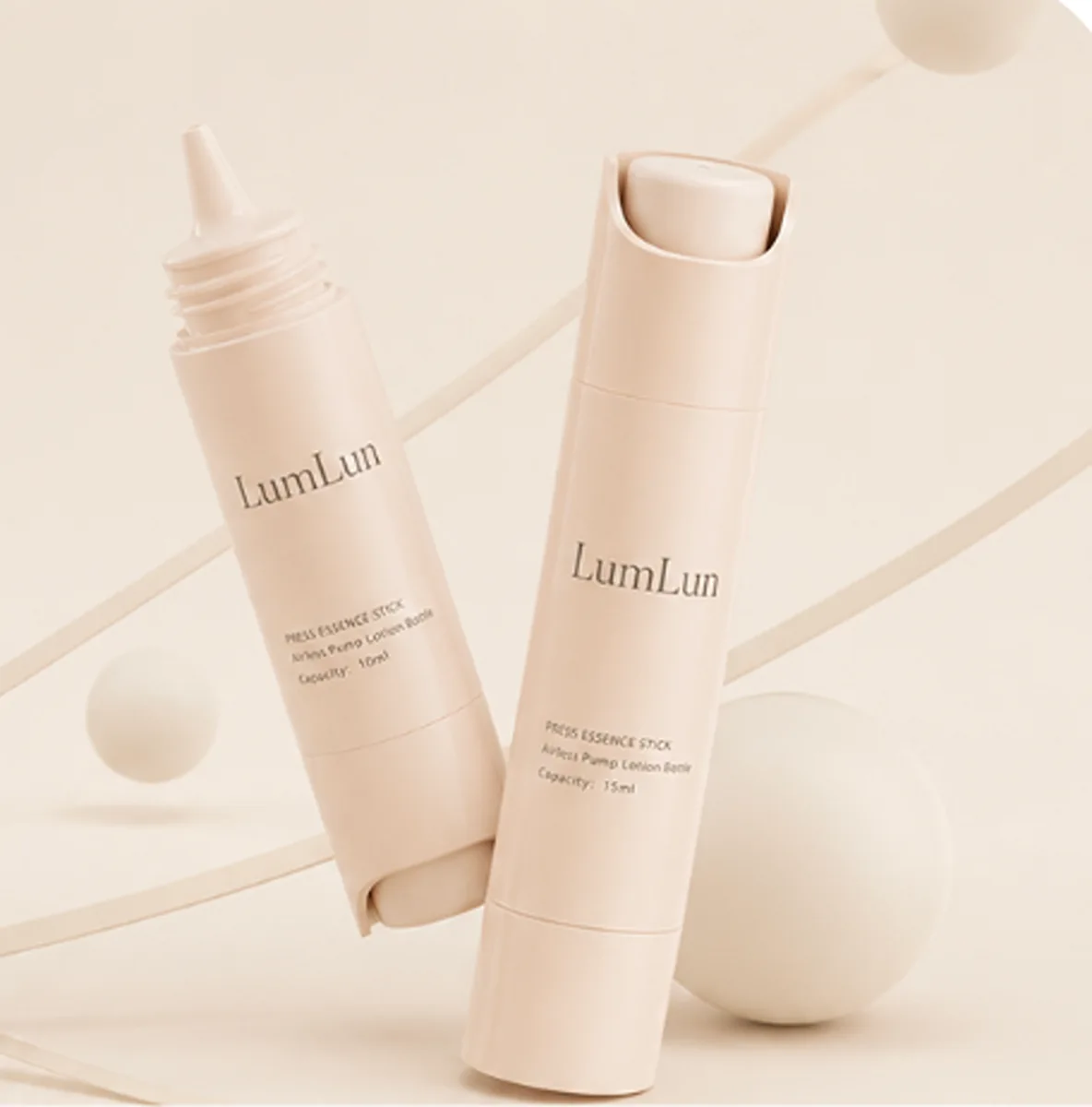 Two beige PP airless press stick bottles — one lying flat showing nozzle tip, one standing upright — slim cylindrical format for serum and essence OEM branding, LumLun custom packaging