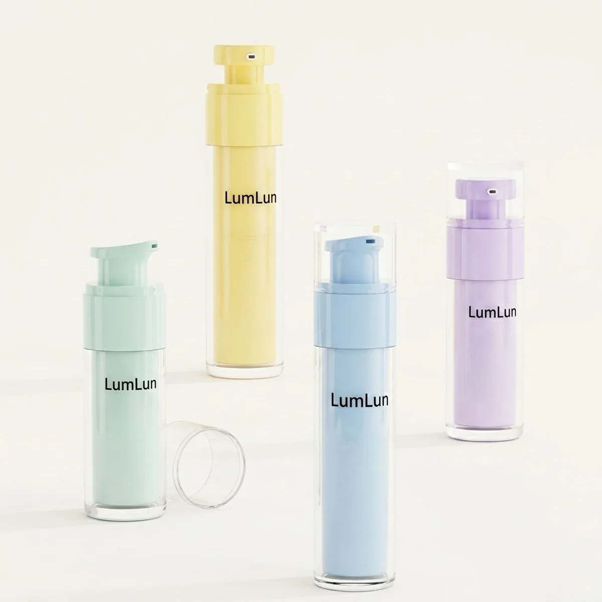 Four LumLun clear PS outer shell replaceable airless bottles displayed at varying heights and positions showing sage green, mustard yellow, sky blue, and lavender PP inner cores through transparent outer shell, with one detached clear PS base ring visible, OEM airless serum lotion packaging