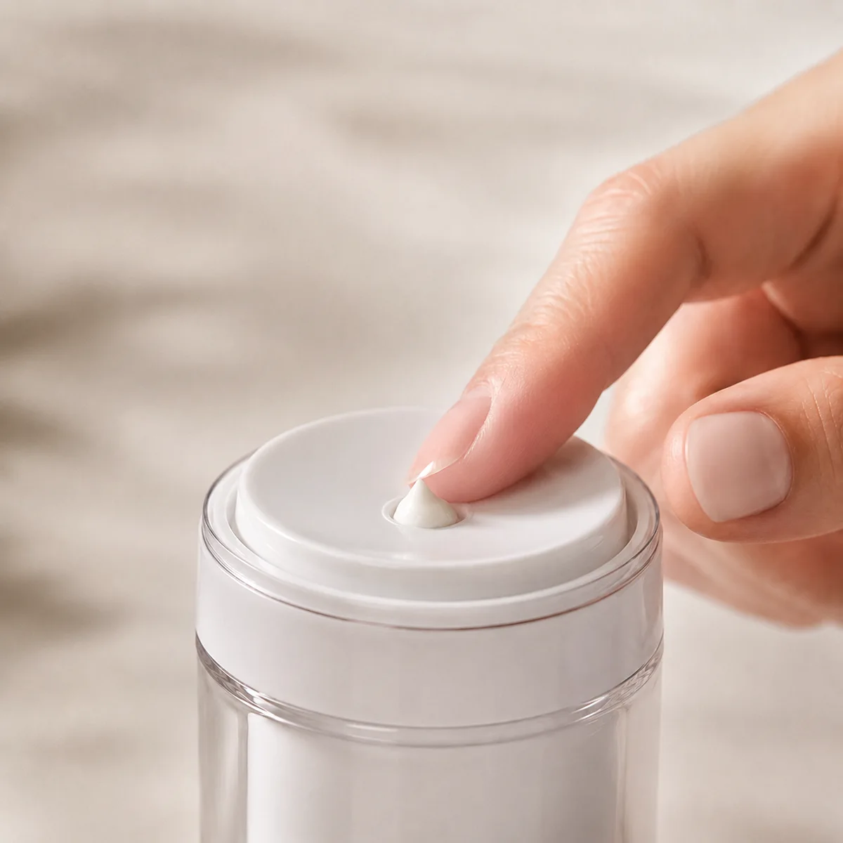 Airless pump jar dispensing cream through a press-top disc without finger contact