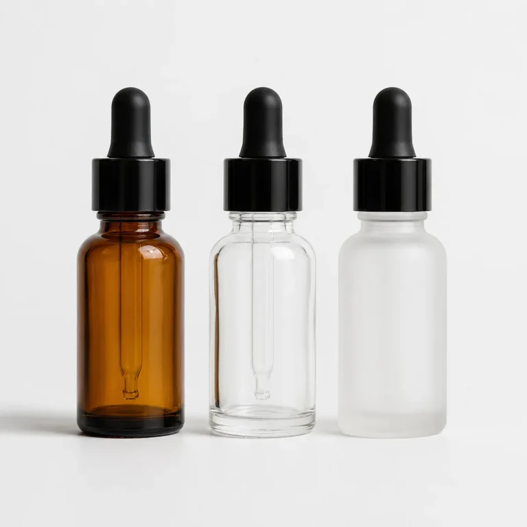 Amber clear and frosted glass dropper bottles with black pipette caps displayed side by side for skincare serum packaging comparison