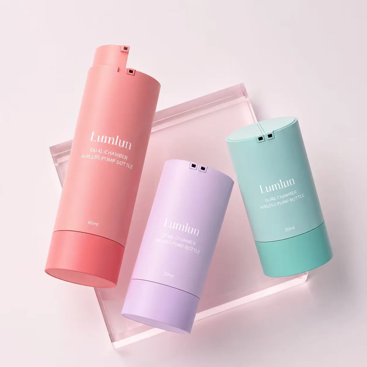 Lumlun twist-open dual chamber airless pump bottles with capless design in coral pink purple and mint green showing twist-to-open dispensing for skincare brands