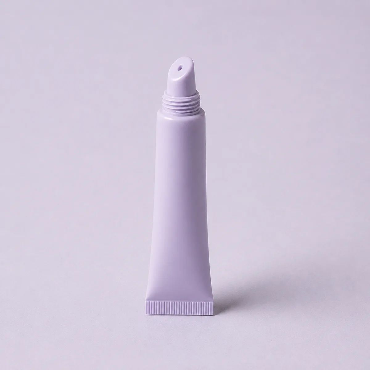 Small lip balm squeeze tube with a slanted applicator tip for hygienic on-the-go lip care