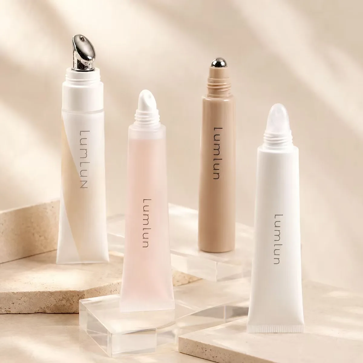 Four LumLun skincare squeeze tubes with different lip serum applicator tips: a silver alloy massage tip, two soft silicone tips, and a metal rollerball