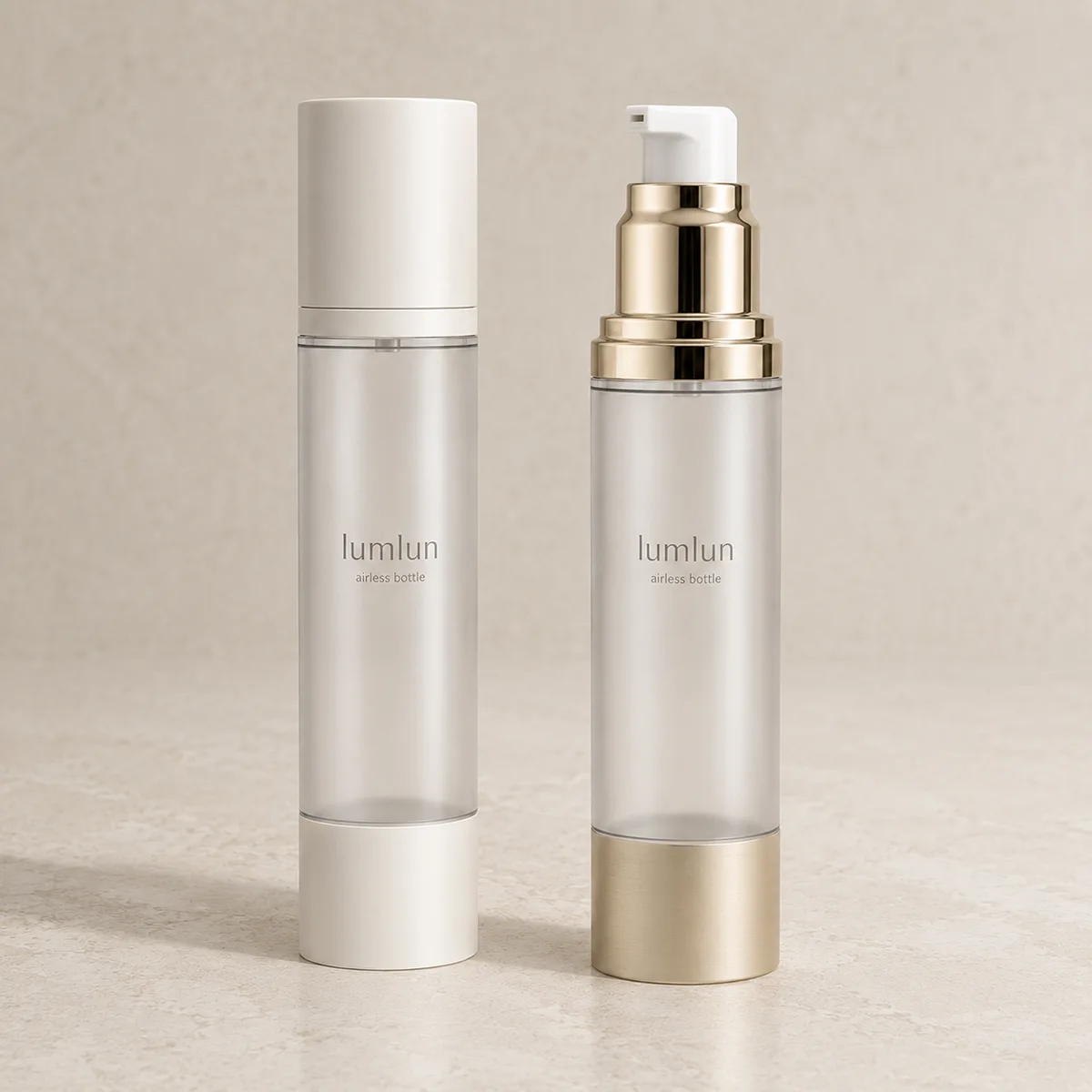 Lumlun airless bottles with clear bodies, showing one closed cap and one gold pump.