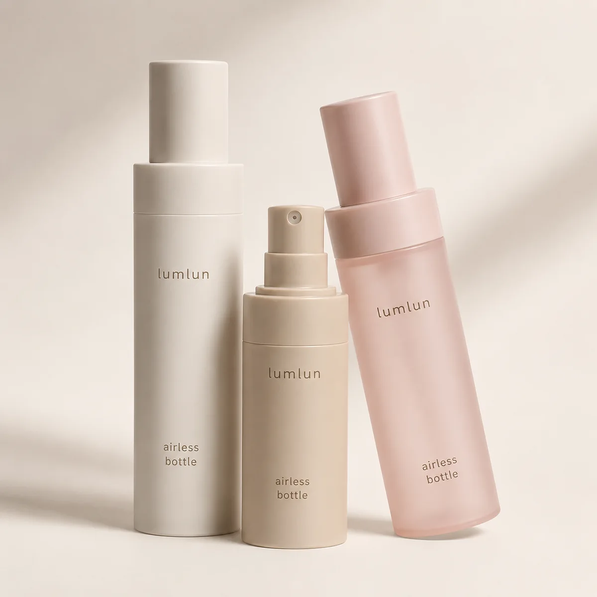 LumLun airless spray bottles in grey, beige and pink, one with a fine-mist spray pump, on a beige background