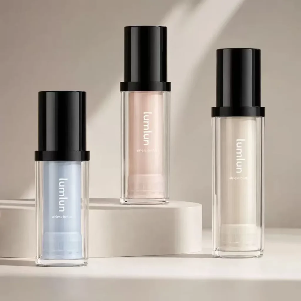 LumLun refillable airless bottles with clear outer shells and black caps, in blue, pink and clear, with visible inner refills