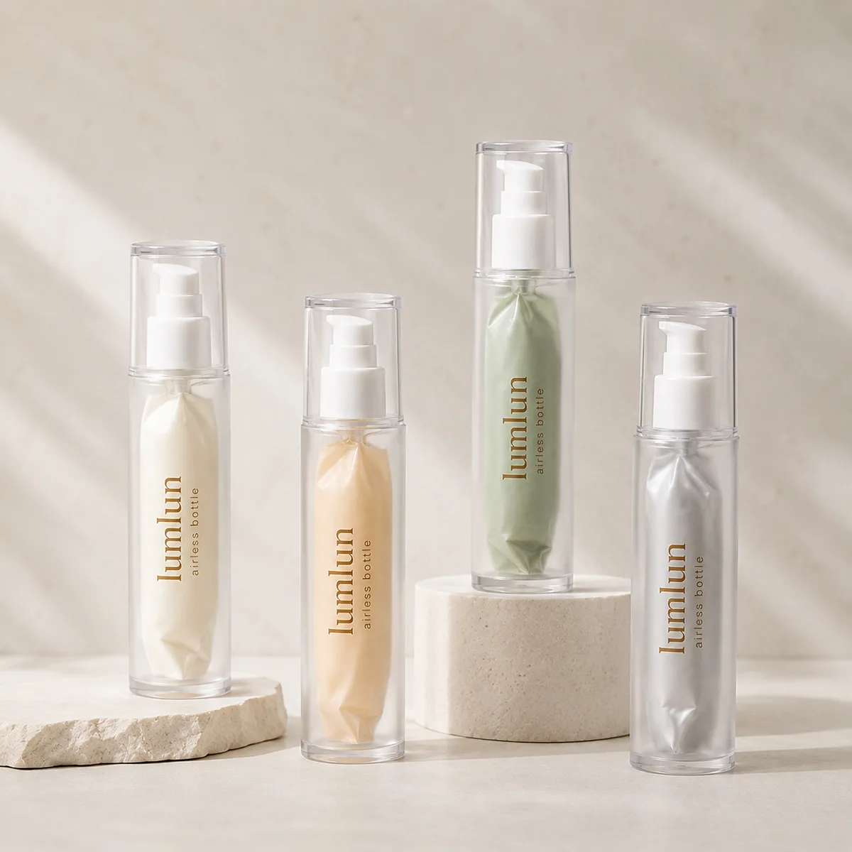 LumLun clear airless bottles with inner pouches holding cream, apricot, green and grey product, on stone