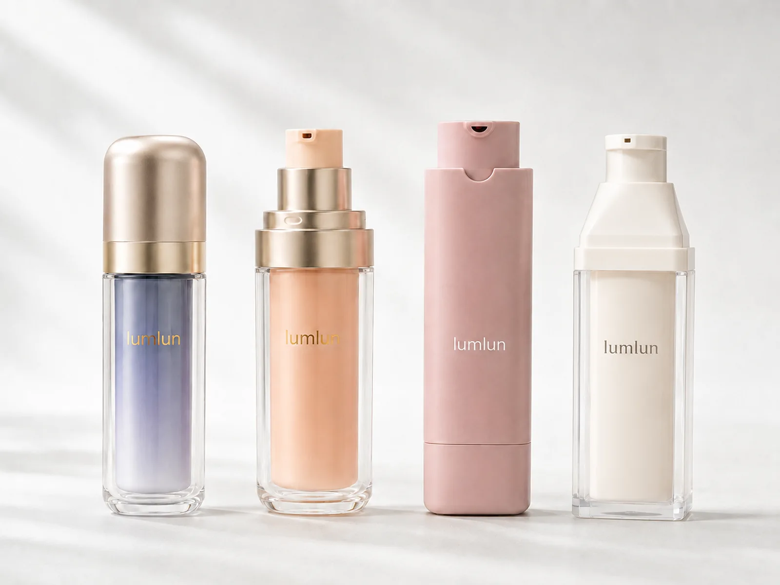 Four LumLun airless bottles in clear, peach, lavender and cream finishes with round, rectangular and square outer shapes