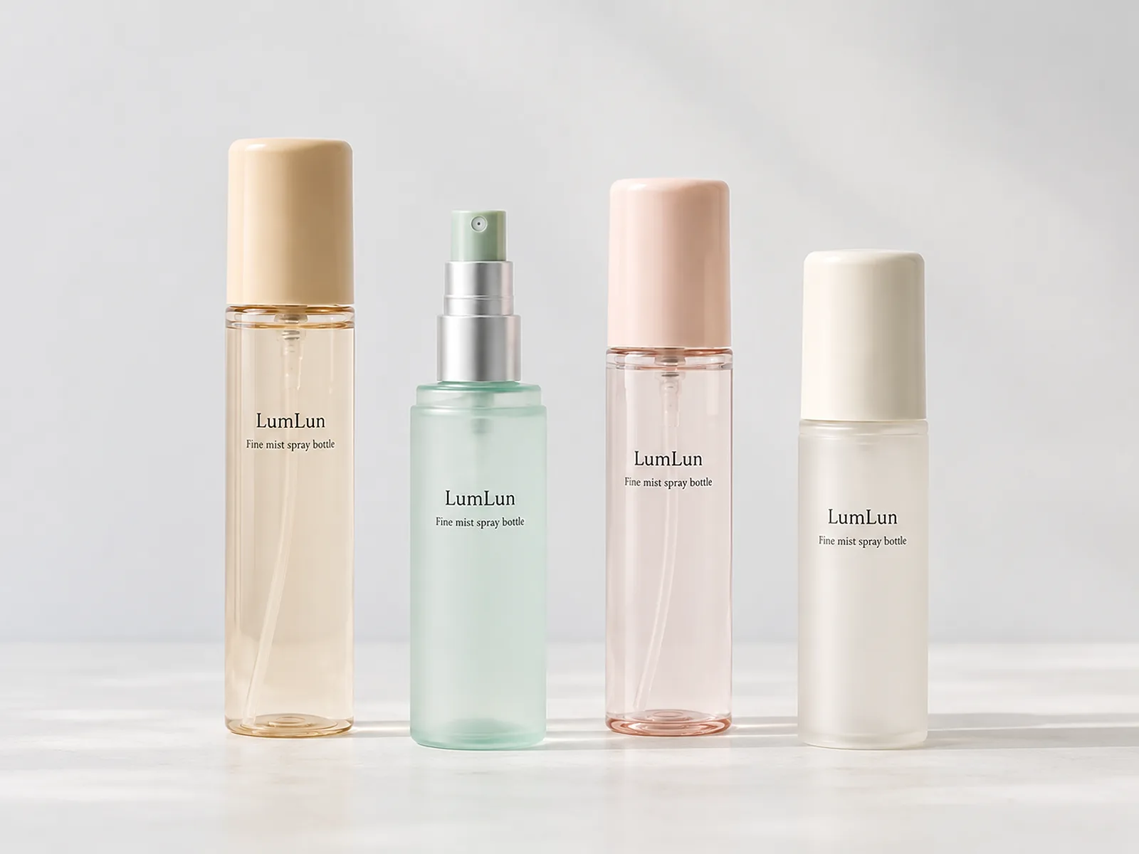 Four LumLun fine mist spray bottles in amber, mint green, blush pink and frosted ivory finishes