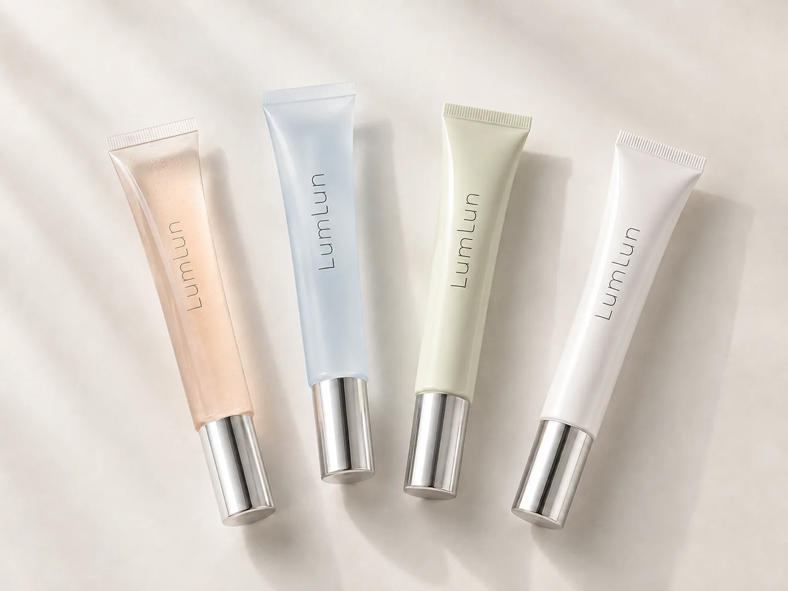 Four LumLun lip gloss squeeze tubes in clear and translucent shade colors
