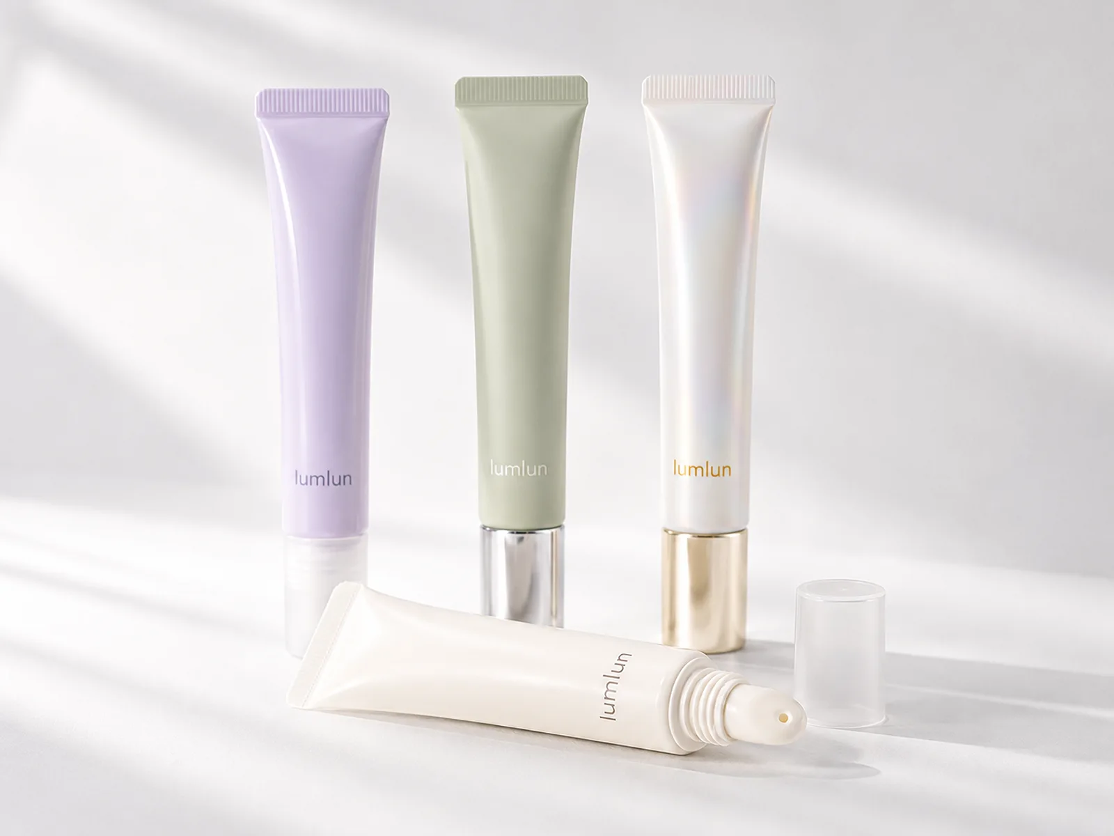 Four LumLun lip gloss squeeze tubes with matte, glossy and metallic-effect cap finishes