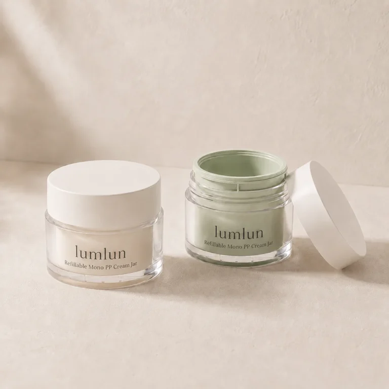 Cream and sage Lumlun refillable cream jars displayed together, one closed and one open.