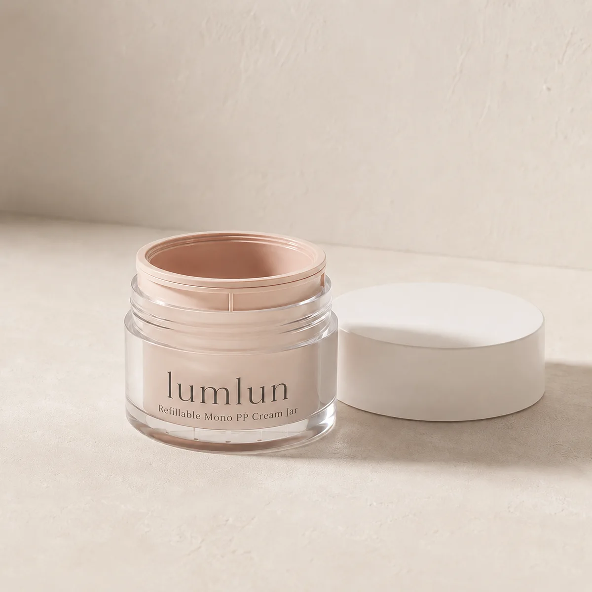 Peach Lumlun refillable cream jar shown open with a white cap on a warm beige surface.