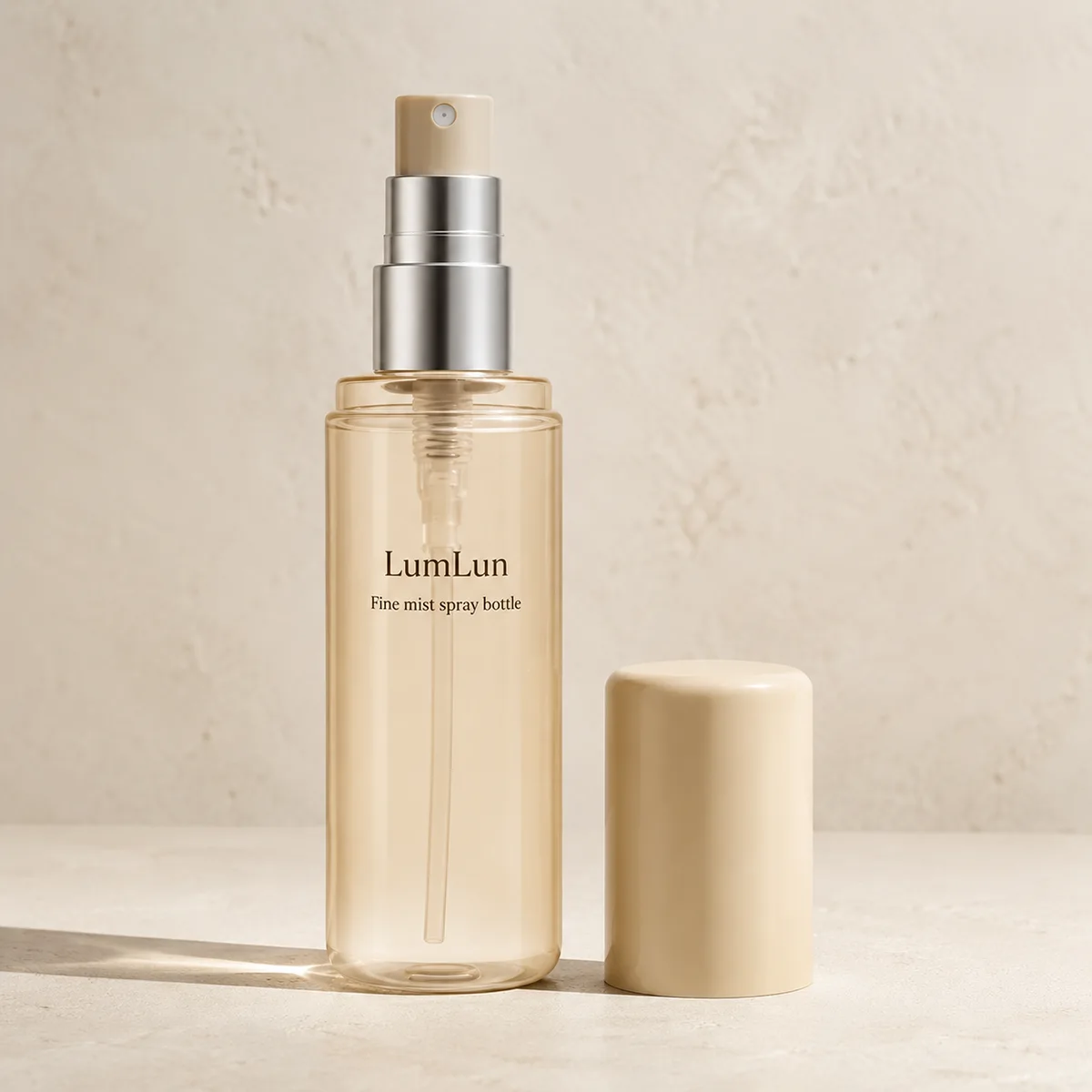 Lumlun 100ml continuous fine mist spray bottle with clear body, beige cap, and exposed spray pump.