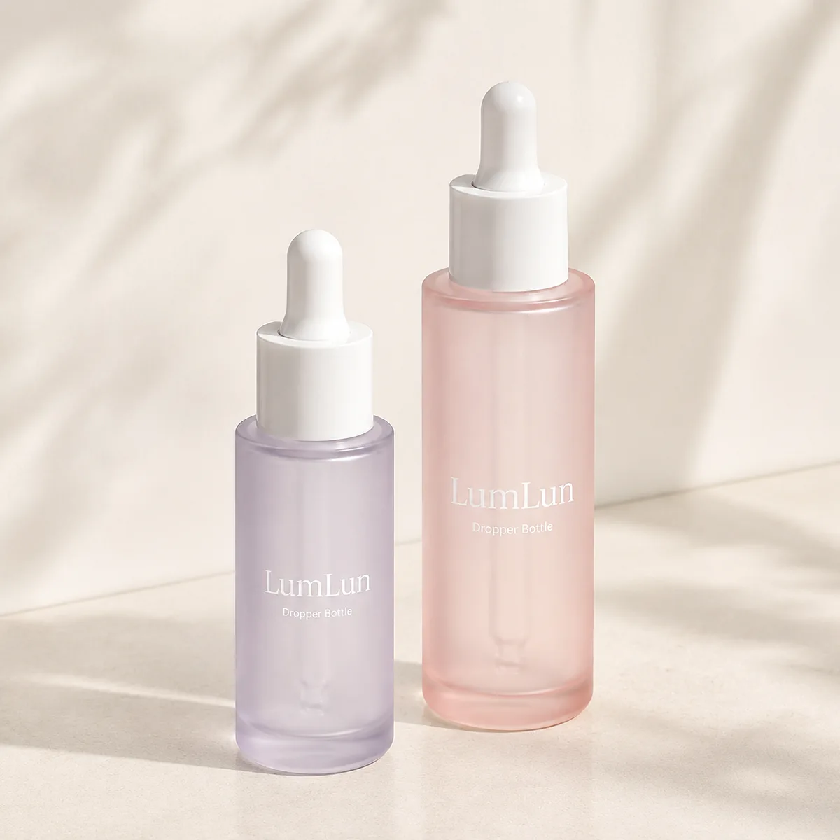 Two Lumlun PET dropper bottles in purple and pink with white droppers standing side by side.
