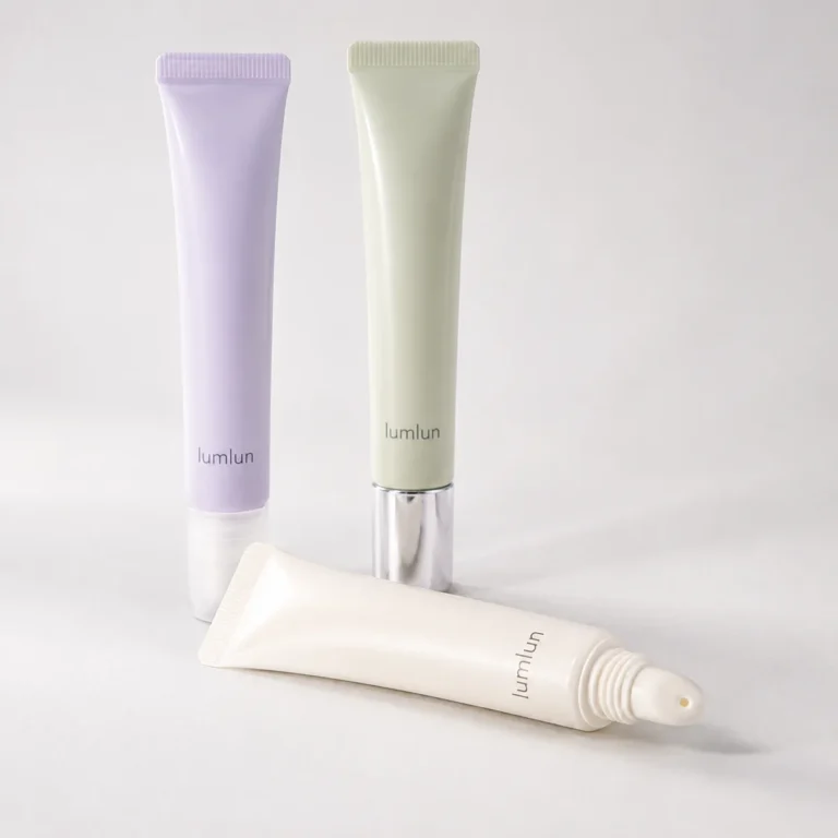 Three LumLun lip gloss squeeze tubes in pastel colors arranged in a clean studio layout with one tube lying in front.