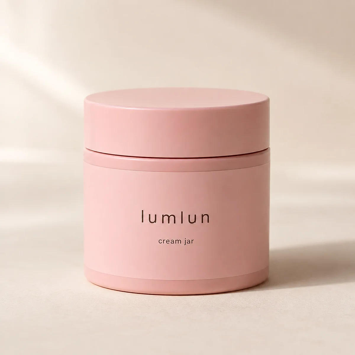 Pink Lumlun cream jar on a warm beige studio background with soft natural shadow.