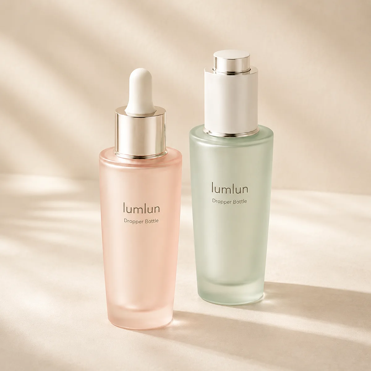 Two glass dropper bottles showing different cap styles in a minimal studio setup.