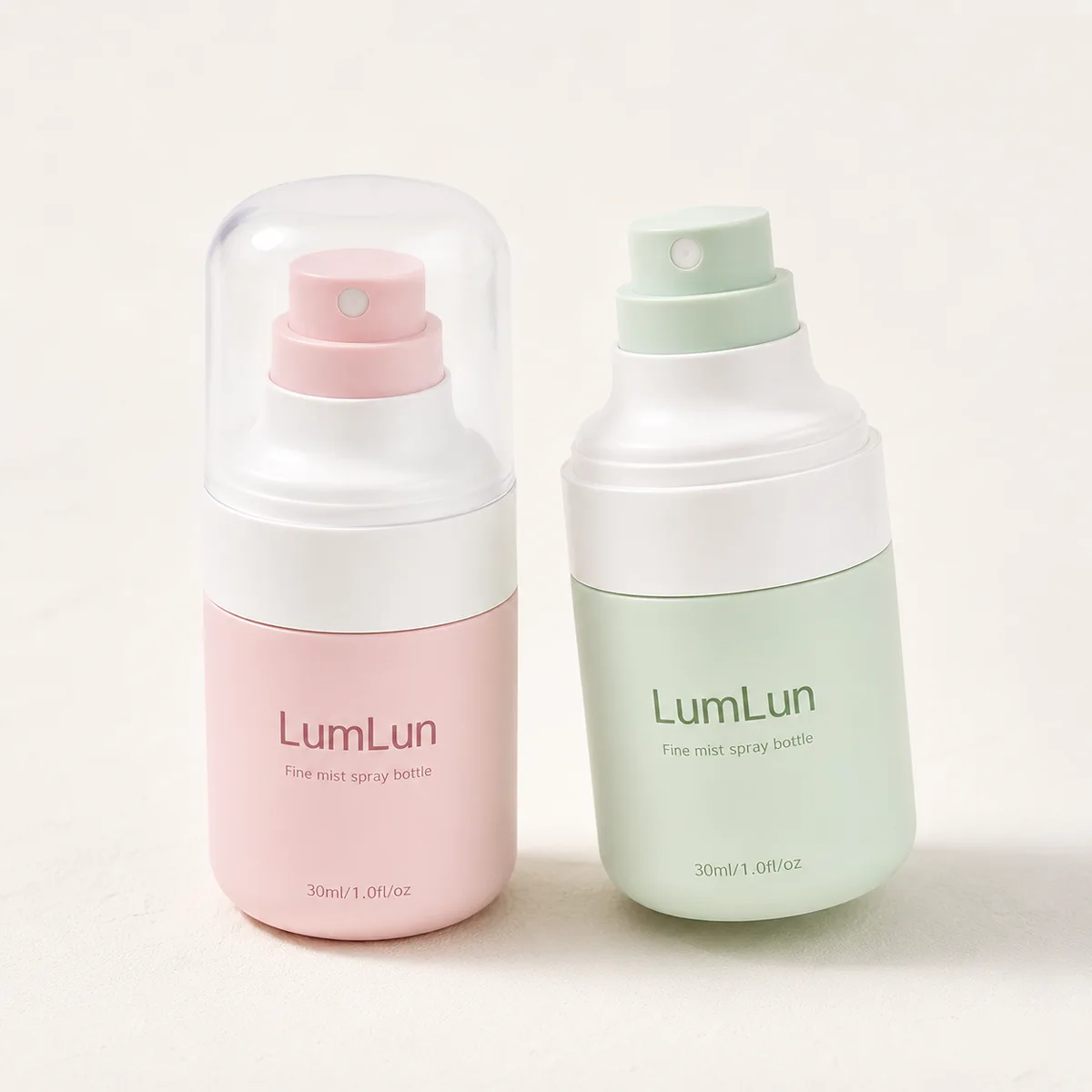 Lumlun 50ml PET fine mist spray bottles in pink and green, one capped and one with exposed sprayer.