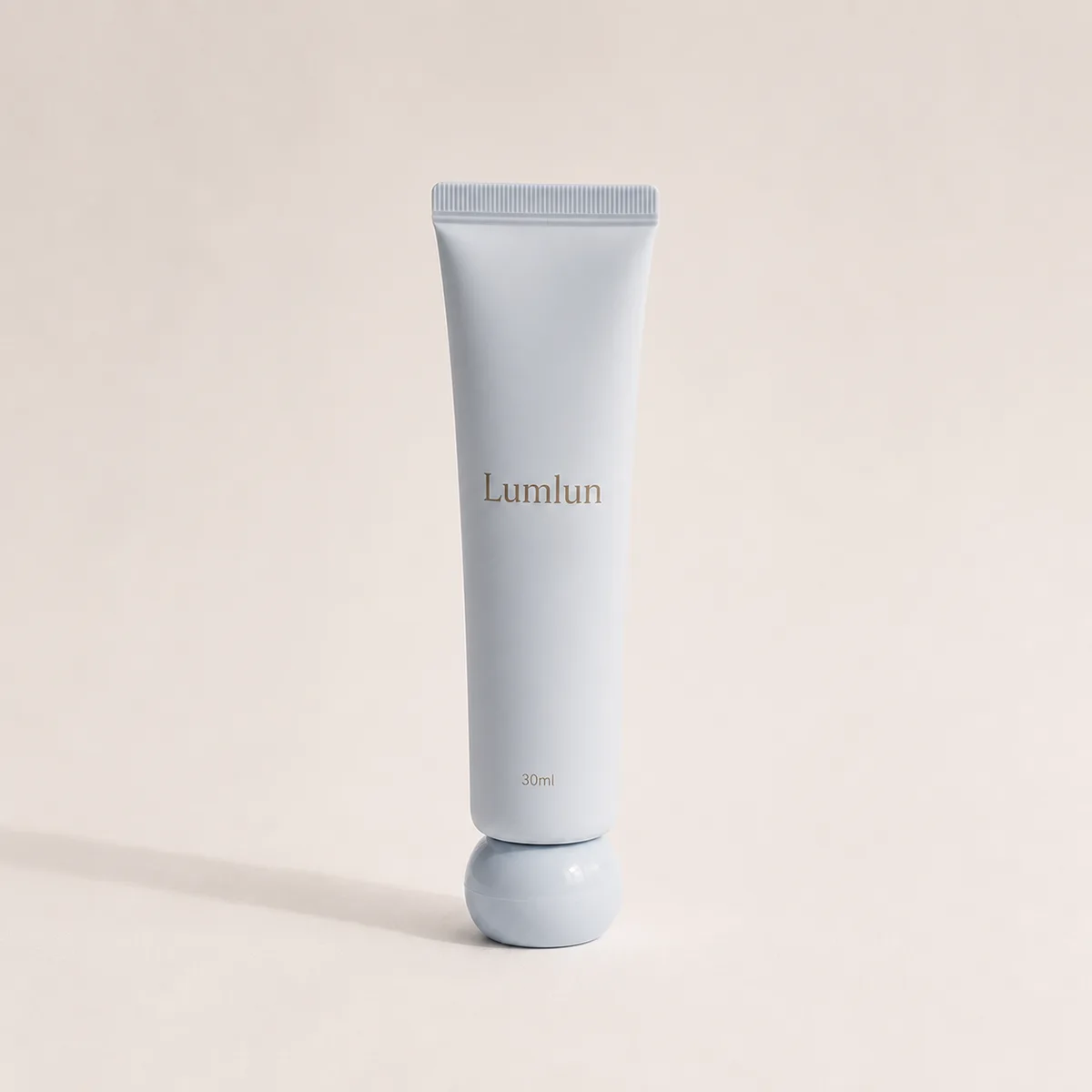A single 30ml Lumlun ball cap hand cream tube in soft blue, standing on a round cap.