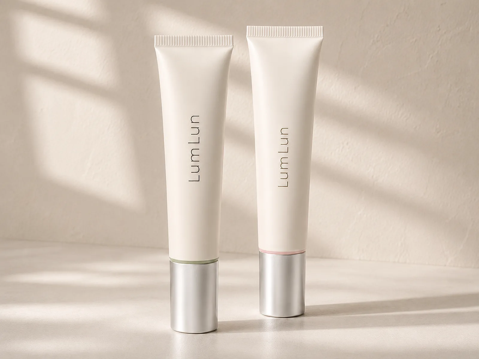 Two coordinated LumLun cosmetic soft tubes with unified white bodies, silver caps, and subtle color accents