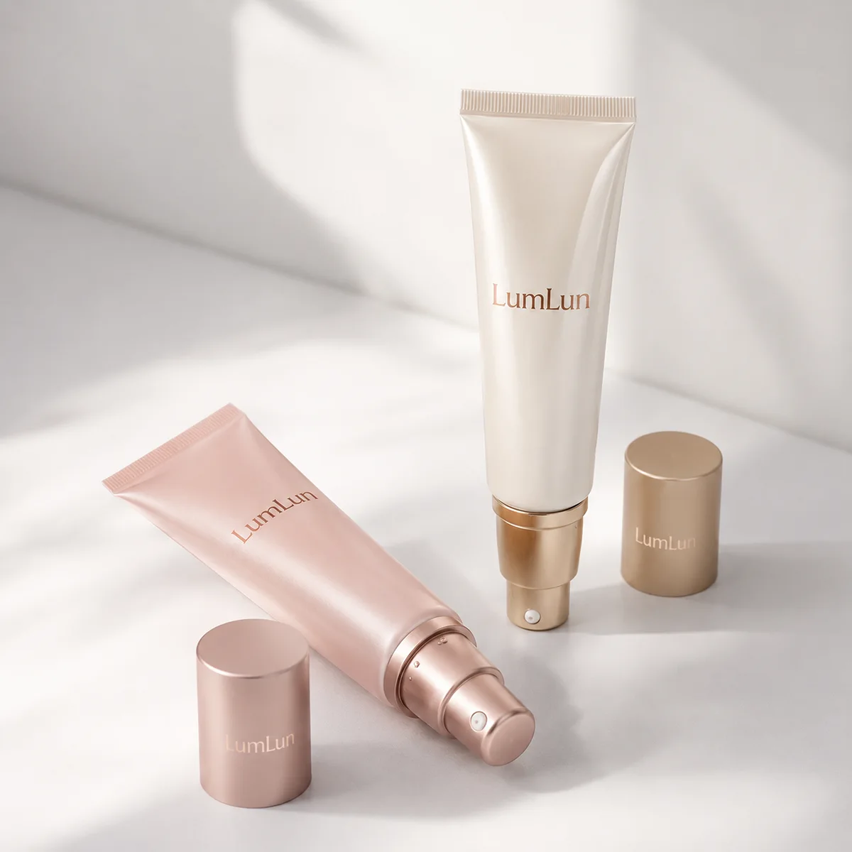 Two LumLun cosmetic tubes in soft pastel tones arranged in a minimal studio layout with clean shadows.