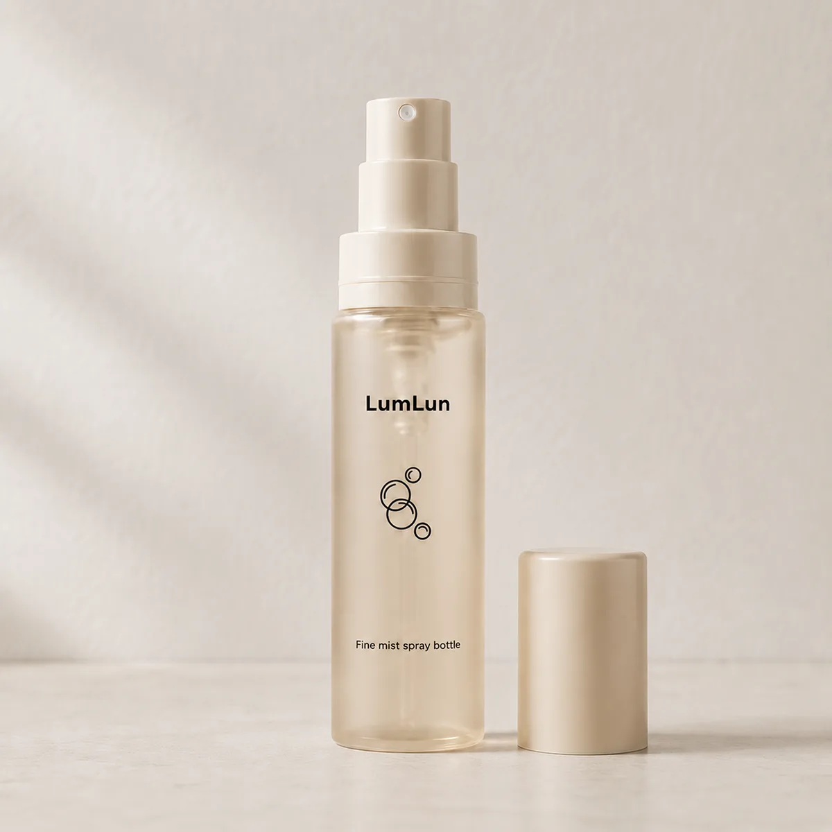 A cream Lumlun fine mist spray bottle with the pump exposed and matching cap beside it.
