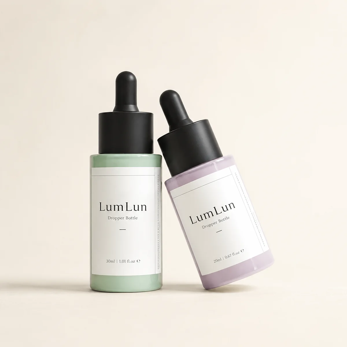 Lumlun flat shoulder glass dropper bottles in green, purple, and blue with white labels and mixed dropper caps.