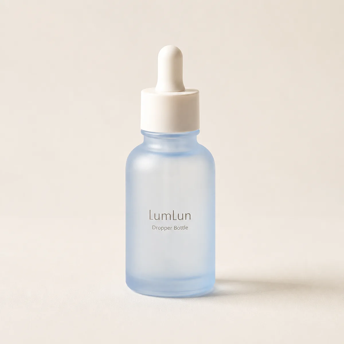 Single frosted blue glass dropper bottle displayed on a clean neutral background with soft shadow lighting.