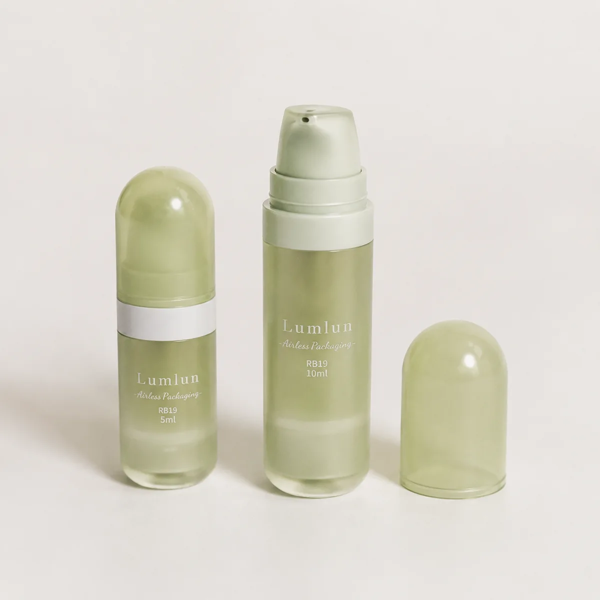 Mini PETG airless pump bottles in two sizes with one outer cap removed