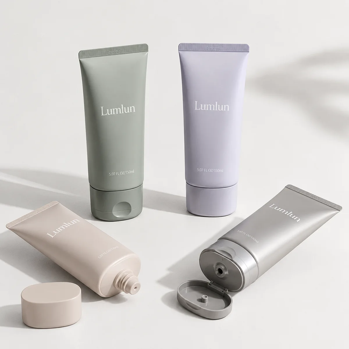 Four Lumlun oval cosmetic tubes 150ml in soft pastel colors arranged upright and one tube opened showing nozzle detail.