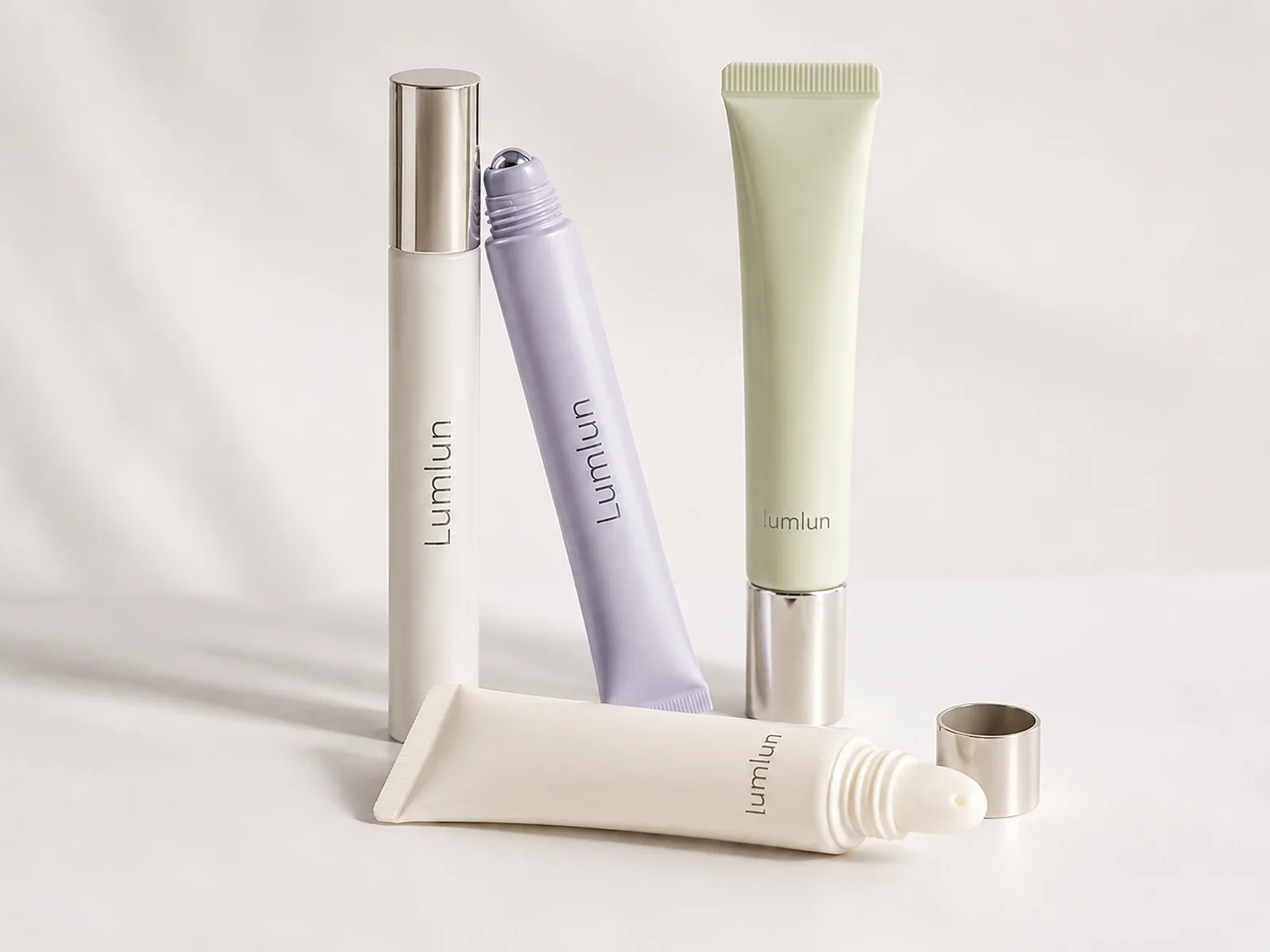Four LumLun lip care packages including slim squeeze tubes with rollerball, rounded applicator and metallic-effect cap designs