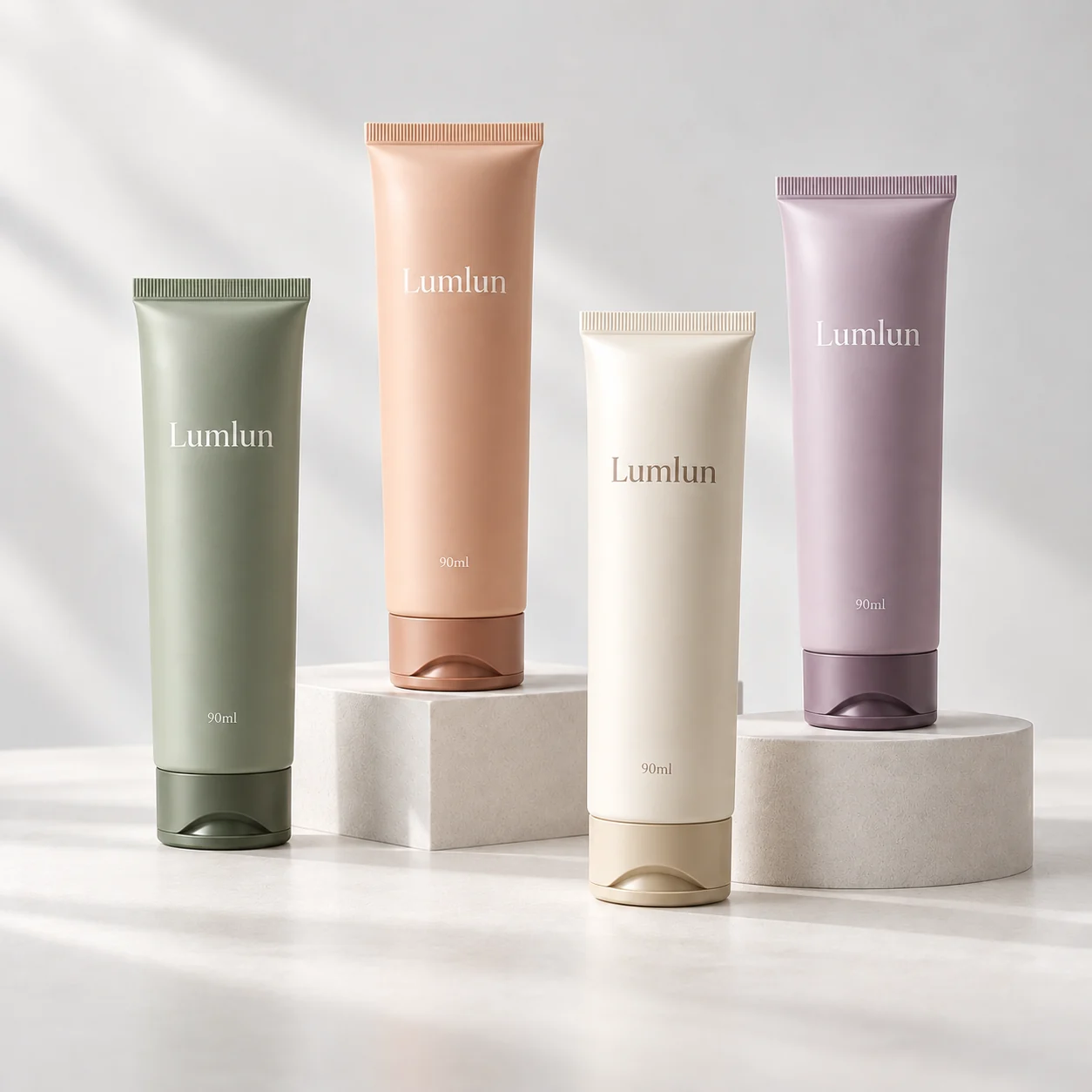 Four pastel 40mm facial cleanser tubes with dark tinted flip-top caps and LumLun logos