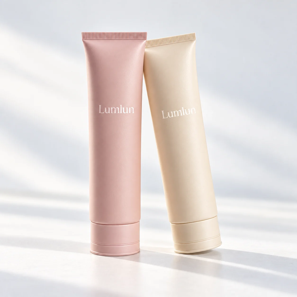 Four facial cleanser tubes in sage, peach, lavender and blue with color-matched caps