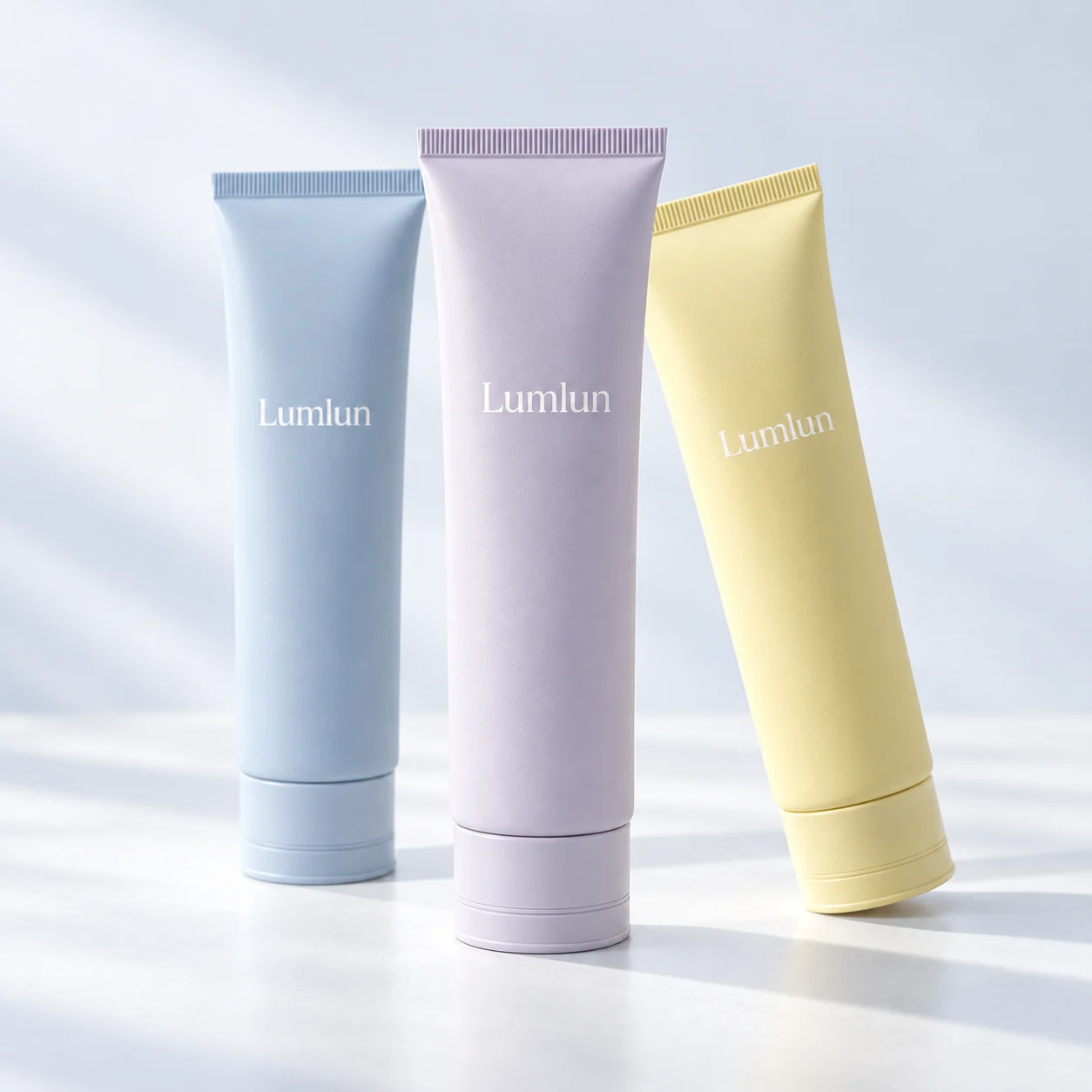Three 40mm cleanser tubes in blue, lavender and yellow with tone-on-tone caps
