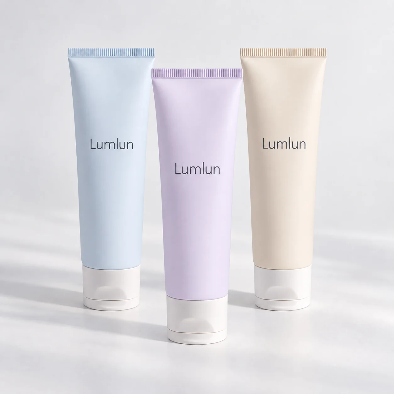 Three pastel cleanser squeeze tubes in blue, lavender and cream with clear-look caps