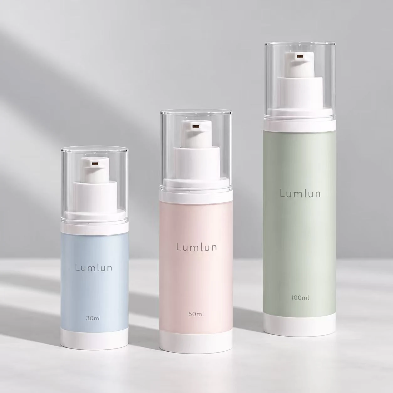Tres botellas airless LumLun de MS + PP con envase interior reemplazable en 30, 50 y 100 ml con cuerpos azul, rosa y verde