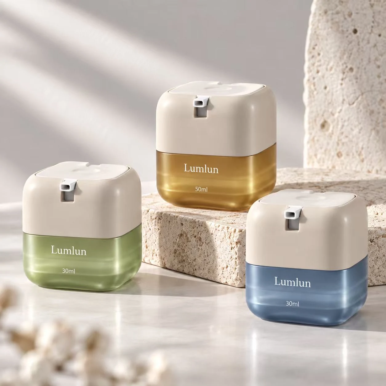Tres tarros airless cuadrados LumLun de PETG en 30 ml y 50 ml con cuerpos inferiores verde, ámbar y azul