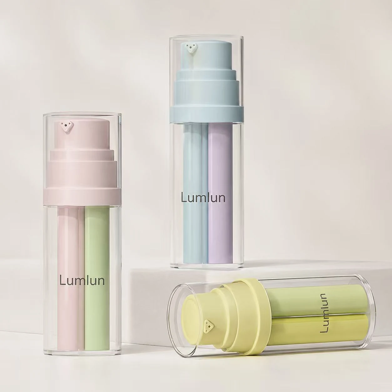 Drei LumLun Dreikammer-Airless-Flaschen in Pastellfarben in stehender und liegender Ansicht