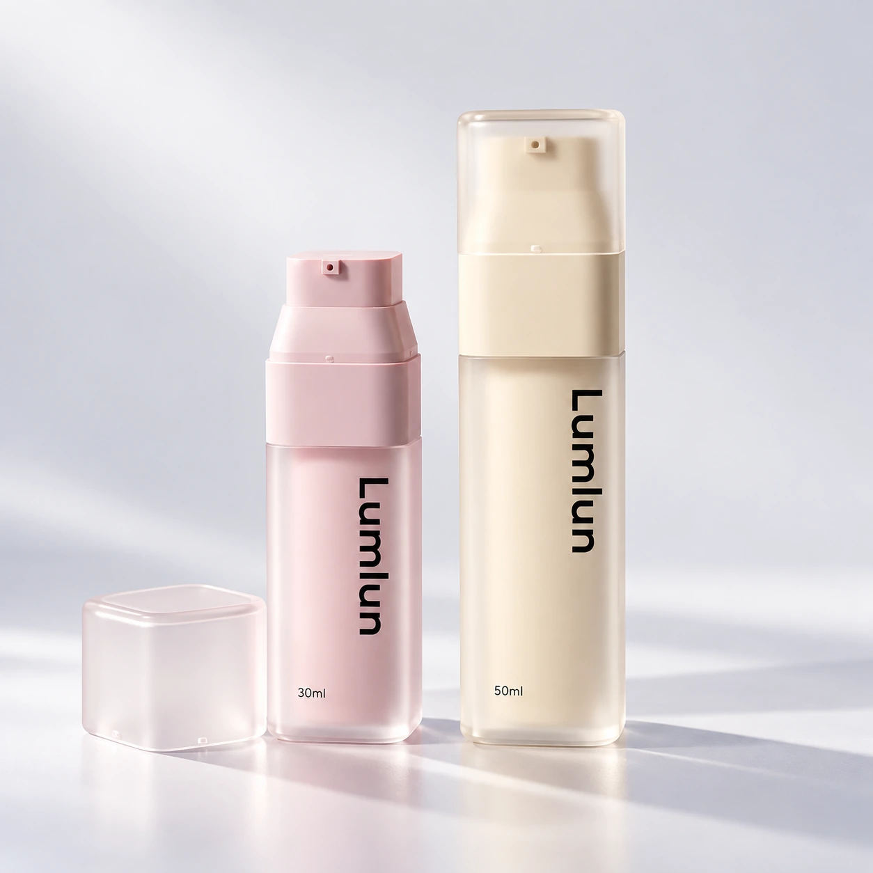Botellas airless cuadradas LumLun de PP + PS en rosa 30 ml y crema 50 ml, con una bomba expuesta y una tapa al lado