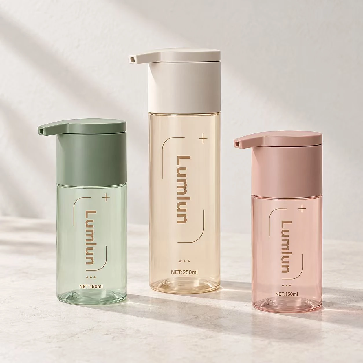 Three clear-window PET wash bottles in green, cream and pink showing compact size options.