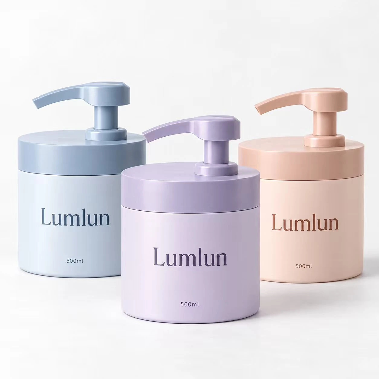 Tres envases PE anchos con bomba en azul pastel, lila y melocotón, todos de 500 ml.