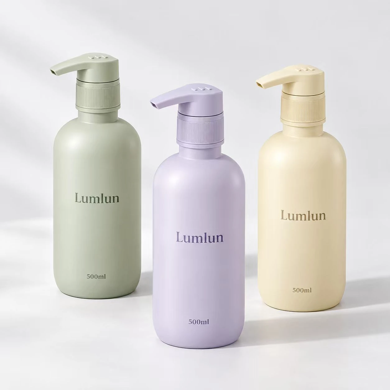Tres botellas PET redondeadas con bomba de 500 ml en verde suave, lila y amarillo claro.